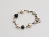 a close up of a bracelet with pearls and charms on it