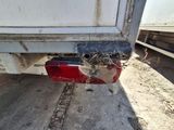 a close up of a red and white truck with a bird nest on the back of it