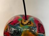une pomme en verre sur laquelle est posé beaucoup d'argent