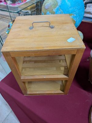 a small wooden table with a suitcase on top of it
