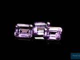 two purple amethtites sitting on top of a black surface