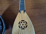 a small wooden instrument on a table next to a bowl