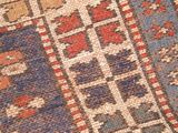 close up of a very old rug with a very colorful design