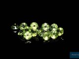 a close up of a group of green gems on a black surface