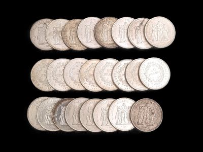 un grand nombre de pièces de monnaie qui se trouvent sur une surface noire