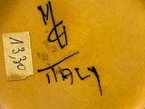 a close up of a yellow vase with writing on it