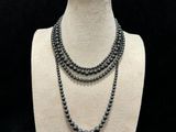 a close up of a necklace on a mannequin with a black background