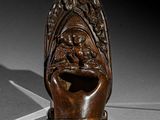 une sculpture en bois représentant une tête avec un visage