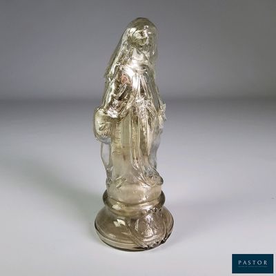 statue d'une femme tenant un panier de fleurs posée sur une surface blanche