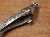 a silver spoon that is on a wooden table