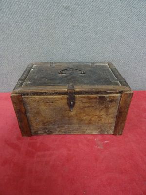 une vieille boîte en bois posée sur un tapis rouge