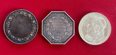 trois pièces d'argent posées les unes à côté des autres sur une surface rouge