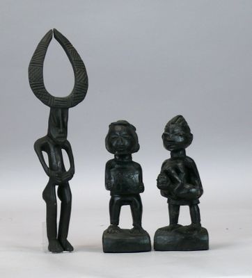 deux figurines noires représentant un homme et une femme tenant une lance