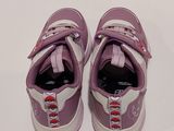 purple and white sneakers with red laces on them on a white surface