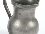 a silver pitcher sitting on a table next to a white background