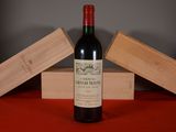 une bouteille de vin posée sur une table à côté d'une caisse en bois