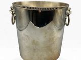 an antique silver plated ice bucket with handles on a white background