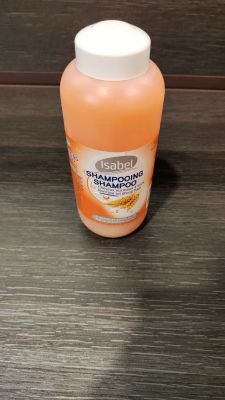 une bouteille de shampoing posée sur une table en bois