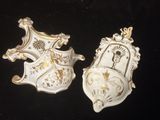 une paire de masques en porcelaine blanche et dorée sur fond noir