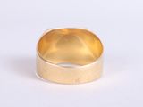 an image of a gold ring on a white surface