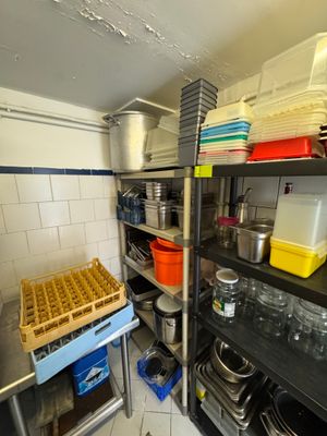 de nombreuses casseroles et poêles sur les étagères de la cuisine