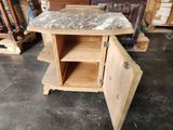 a small table with a marble top in a warehouse