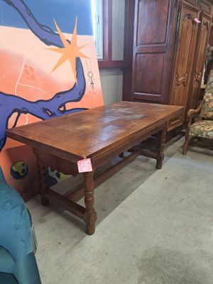 une table en bois sur laquelle est posé un tableau, dans une pièce