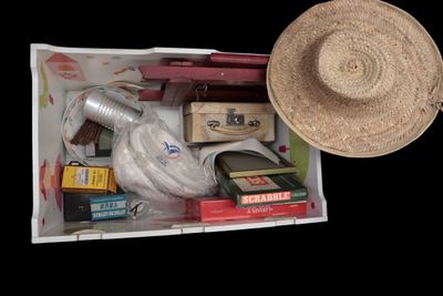 a straw hat sitting on top of a box filled with books