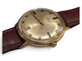 an image of a gold watch with brown leather straps