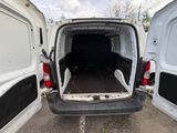 the back of a white van with its doors open in a parking lot
