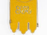 a close up of a yellow wall hanging with a monogram on it