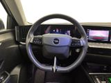 a steering wheel and dashboard of a car with a laptop on the table