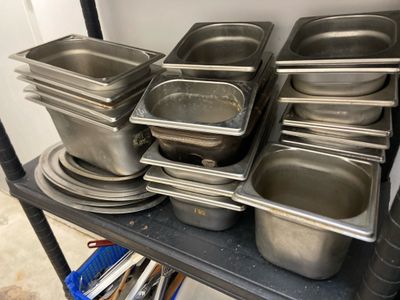 many pans and pans on a shelf in the kitchen