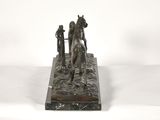 bronze statue of a man and a horse on a marble base
