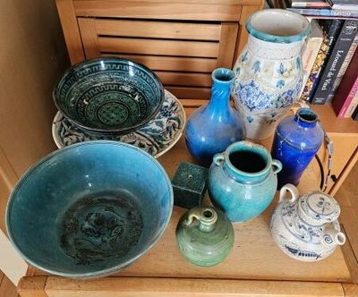 many vases and bowls sitting on a shelf