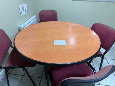 une table ronde entourée de quatre chaises dans une pièce