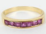 a close up of a gold ring with pink stones on it