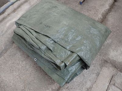 a green tarp laying on the ground next to a bike