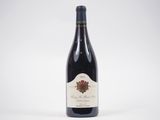 une bouteille de vin rouge posée sur une table blanche