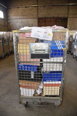 a metal cart with many boxes on it in a warehouse