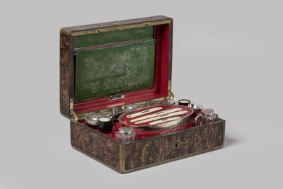 a small wooden box with a silver plate inside of it