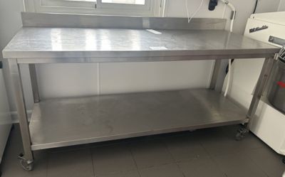 a stainless steel table in a kitchen with a washing machine