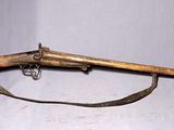 un vieux fusil avec une crosse en bois et un étui en cuir