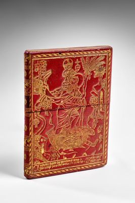 an antique red and gold book with a picture of a woman on a horse