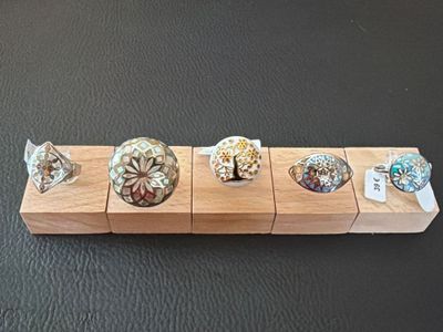 five rings on a wooden stand on a table