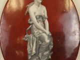 a picture of a statue of a woman on a red plate