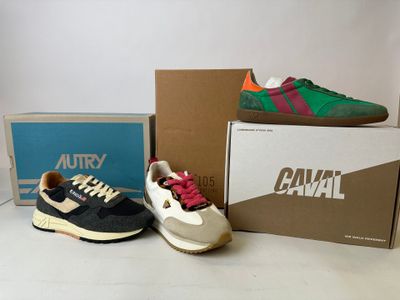two pairs of shoes sitting on top of a table next to a box