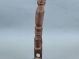une petite statue en bois représentant un homme au long cou