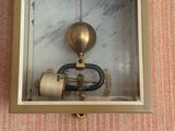 a clock that is in a glass case on the wall