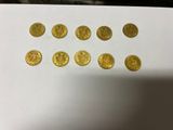 a bunch of gold coins sitting on top of a white table